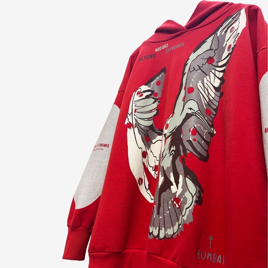 An oversized red hoodie featuring a prominent eagle design, embodying luxury street style in Indian streetwear by Beyond Extremes.